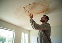 Propriétaire inquiet inspectant des dégâts d'eau au plafond dans un salon lumineux en Floride