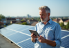 Panneaux solaires : quel contrat choisir pour une installation efficace ? Homme d'âge moyen sur un toit solaire en ville